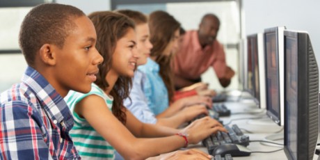 Group Of Students Working At Computers In Classroom